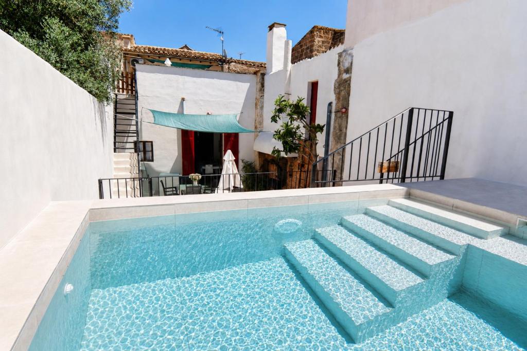 a swimming pool with stairs in front of a house at 229 Casa Es Forn ETV10429 by Mallorca Charme in Petra