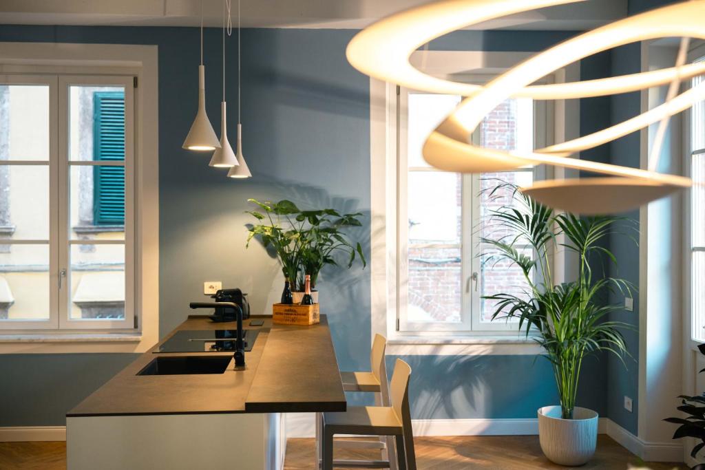 a kitchen with blue walls and a table with plants at Anfiteatro - Spacious and elegant residence in Lucca