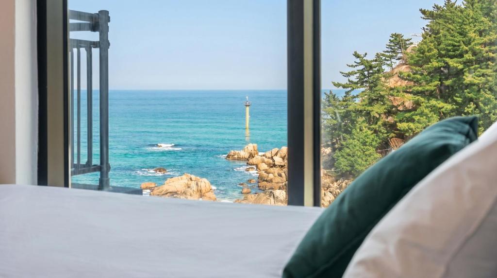a room with a window looking out at the ocean at Capella Oceanview Spa Resort – Goseong in Goseong