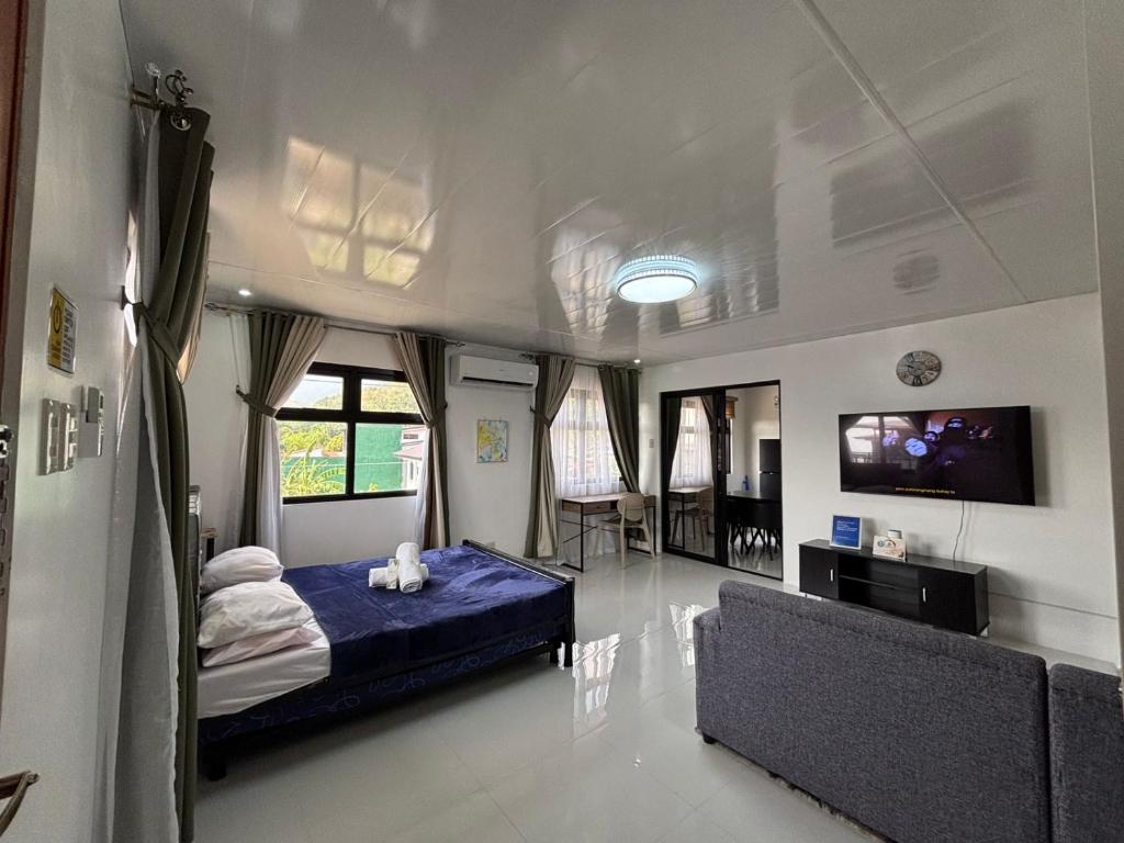 a bedroom with a blue bed and a couch at Stay at Diez in Calamba