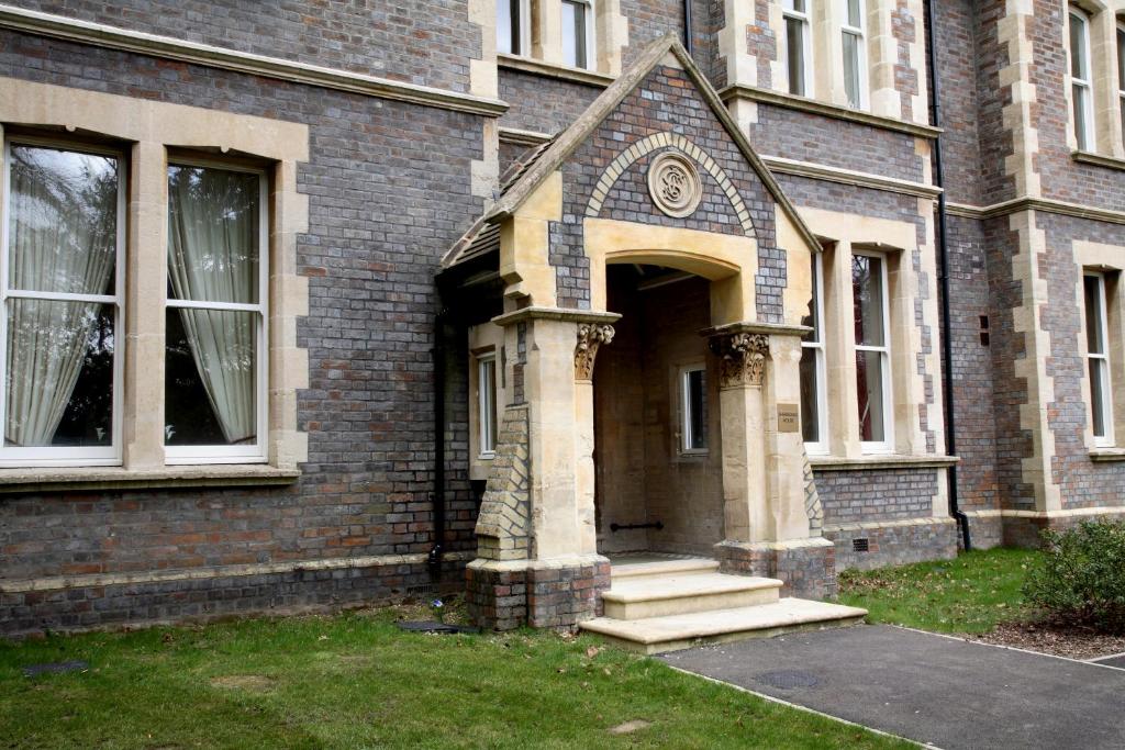 a brick building with a door with a clock on it at Sherborne House, City Centre Victorian Apartments in Basingstoke