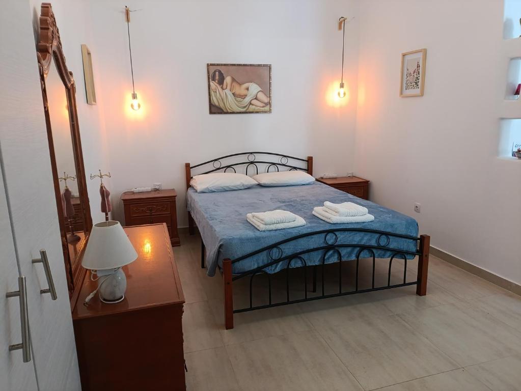 a bedroom with a bed and a table with a lamp at Gorgona in Loutra