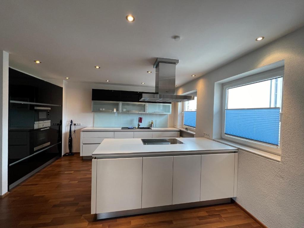a kitchen with white cabinets and a large window at chapter-one in Innsbruck