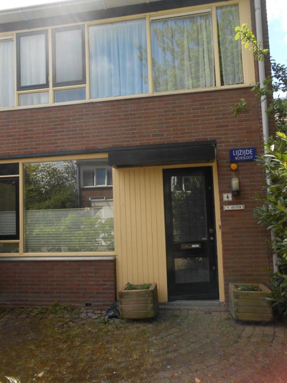 ein Backsteingebäude mit einer Tür davor in der Unterkunft Hetem's Room in Amsterdam