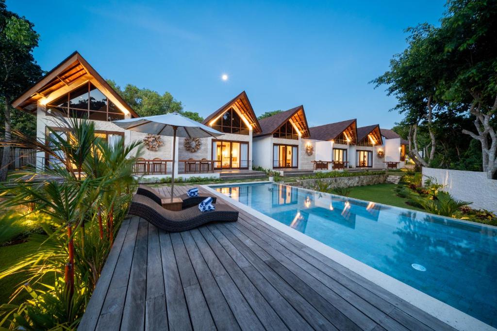 a house with a swimming pool and a wooden deck at Nayandra Uluwatu in Uluwatu