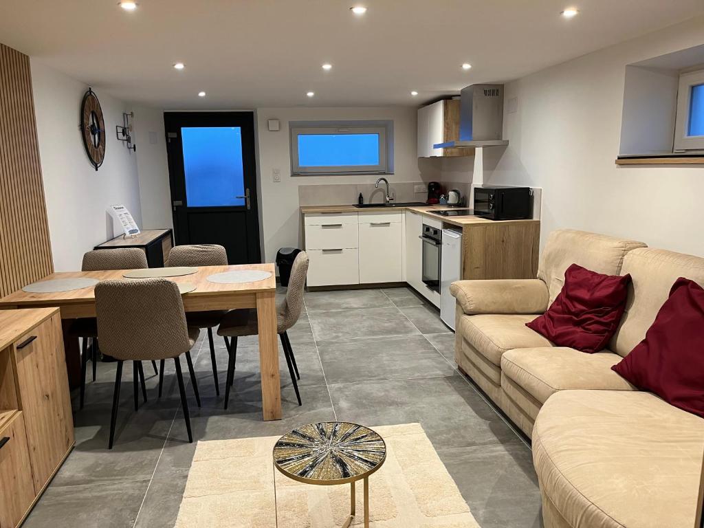 a kitchen and living room with a couch and a table at Les champs étoilé in Morschwiller