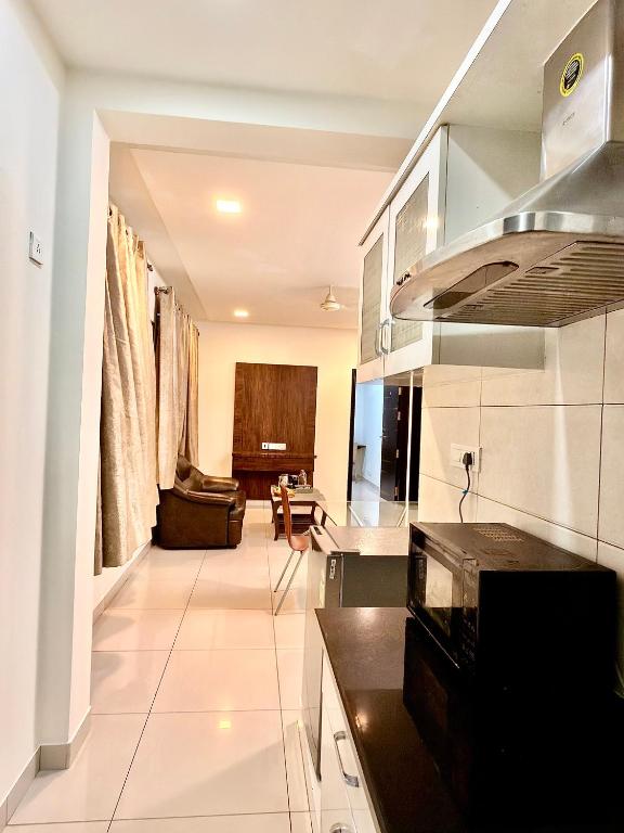 a kitchen and living room with a couch at The Staying Co in Bangalore