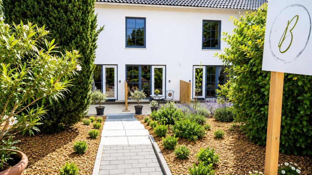 a garden with a sign in front of a house at Ferienzimmer BlatnerS Bissersheim in Bissersheim
