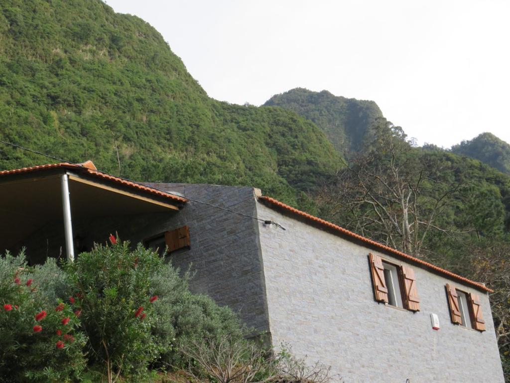 a house on a hill with mountains in the background at Chalé Da Melaria in São Vicente