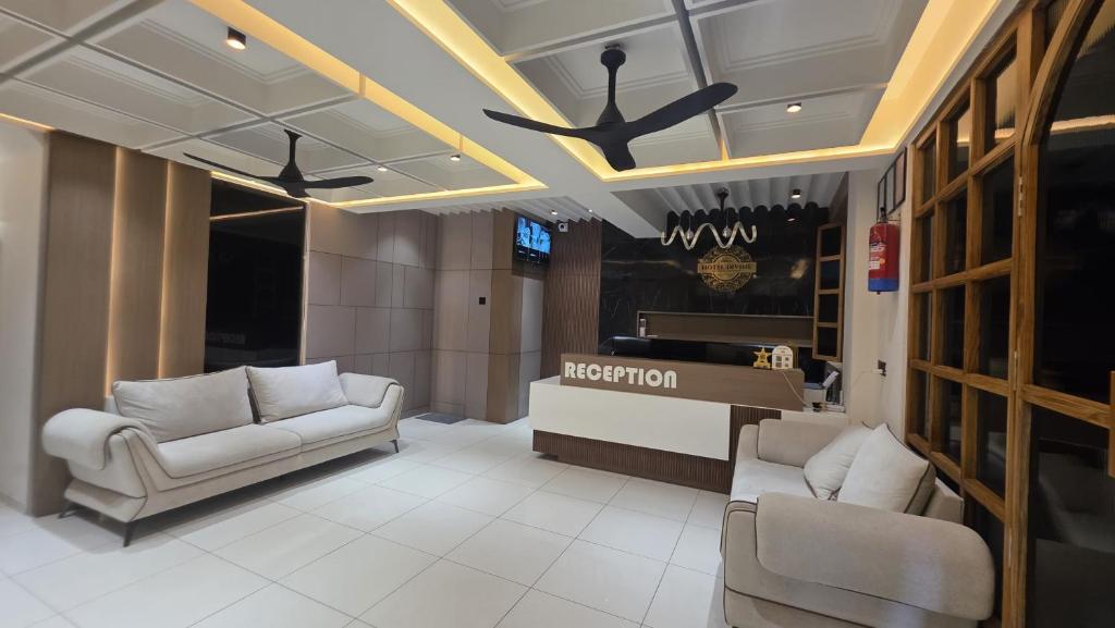 a lobby with two chairs and a reception desk at Hotel Divine in Junagadh