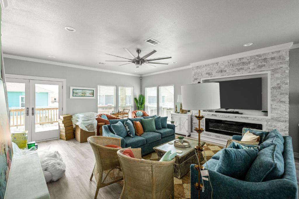 a living room with blue couches and a tv at The Elevated Spoonbill Dog-Friendly Beach Retreat in Bolivar Peninsula
