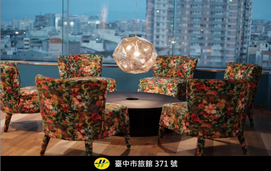 a room with chairs and a table and a window at Happy Inn in Taichung