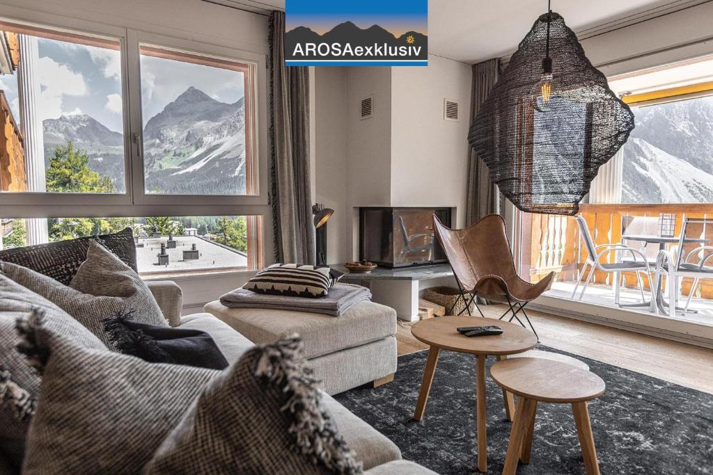 a living room with a couch and a table and a tv at Amselfluh in Arosa