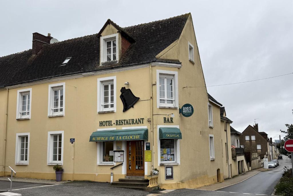 a large yellow building on a street at Logis hôtel restaurant Auberge de la Cloche in Le Theil-sur-Huisne