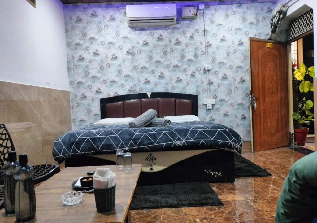 a bedroom with a bed with a blue comforter at The Kishan's Nest in Mathura