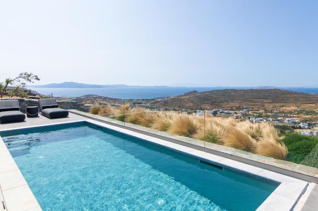 a swimming pool with a view of the ocean at Tinos Prinos 3 in Agios Fokas