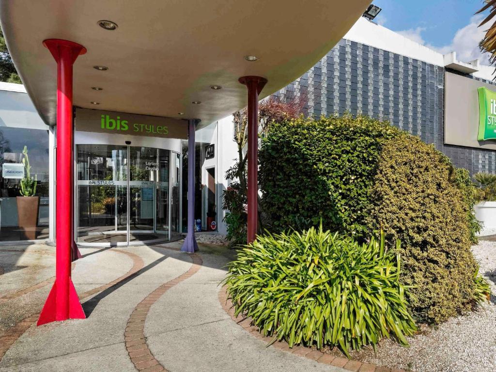 a building with red columns in front of a building at ibis Styles Lorient Caudan in Caudan