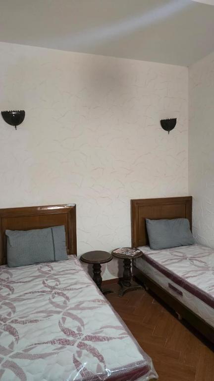 a room with two beds and a table in it at Appement in Agadir nʼ Aït Sa