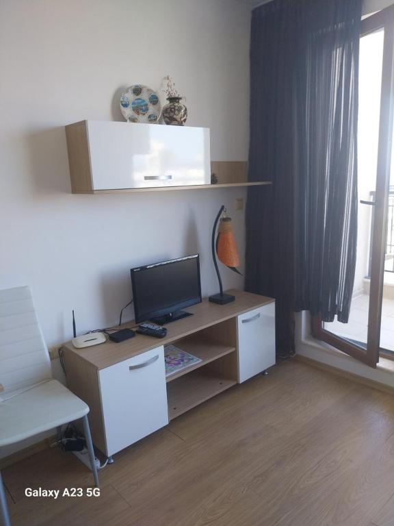 a room with a desk with a computer and a window at Апартамент Нина in Byala