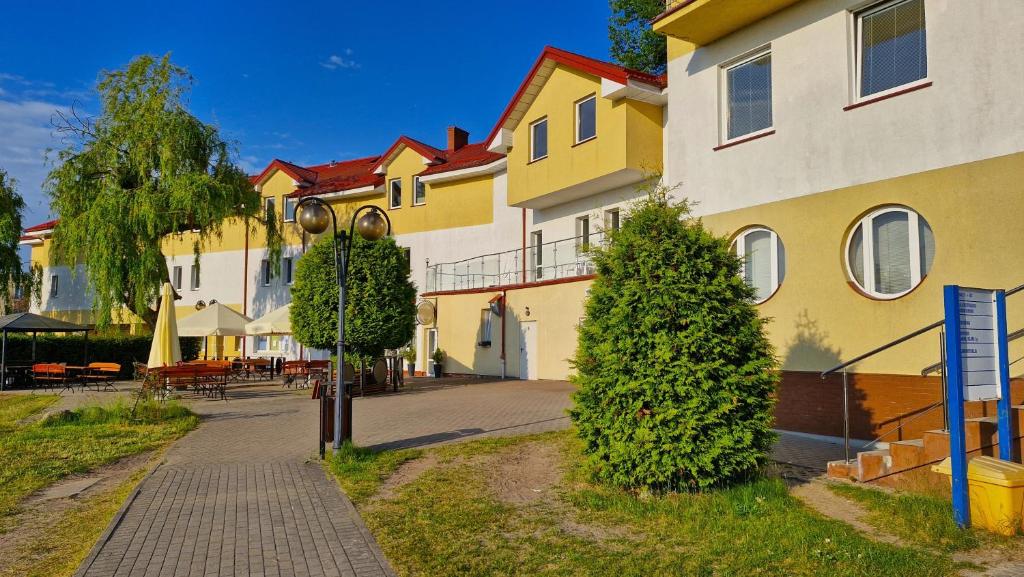 a row of houses with trees next to a sidewalk at Hotelik MOSiR Reda in Reda