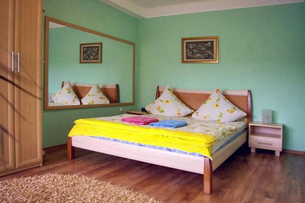 a bedroom with a bed with yellow sheets and a mirror at Apartment on Sobornyi Avenue in Zaporozhye