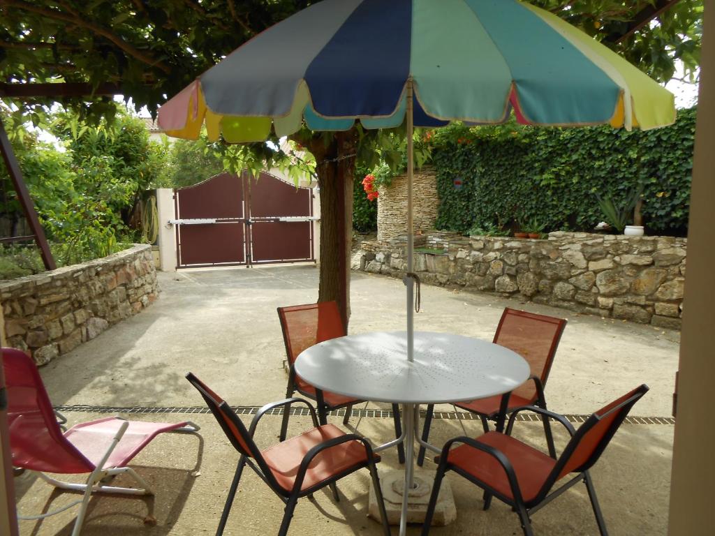 a table with chairs and an umbrella at Herault Maraussan in Maraussan