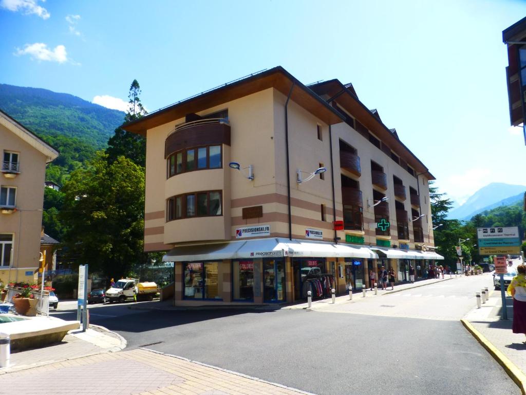 a building on a street in a town with mountains at Résidence Le Grand Chalet in Brides-les-Bains