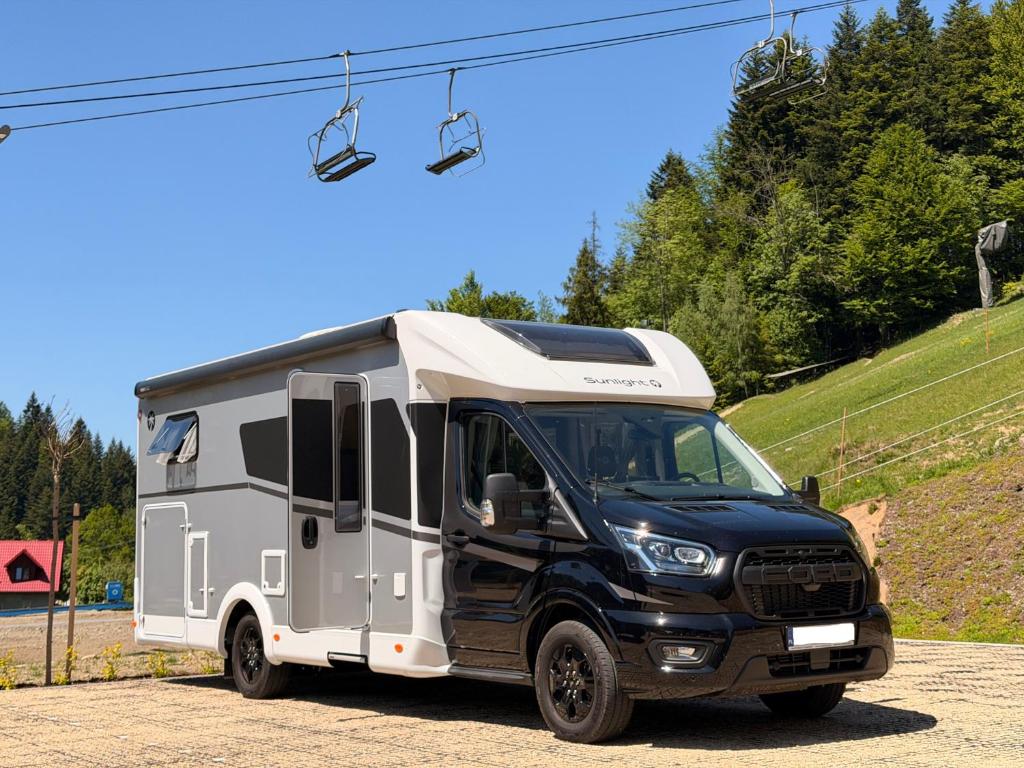 a truck with a camper parked on a road at Kamper Park Babia Góra - parcele kamperowe in Zawoja