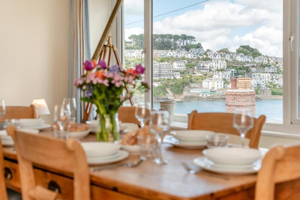 a dining room table with a view of the water at 3 Bed in Polruan oc-pc049 in Fowey