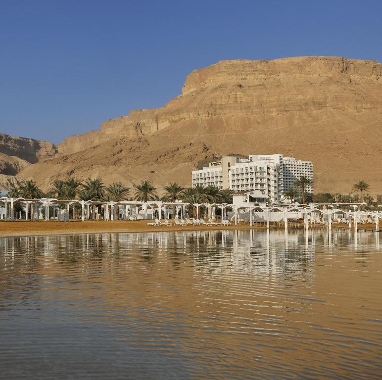 a building on the shore of a body of water at Herbert Samuel Hod Dead Sea Hotel in Ein Bokek