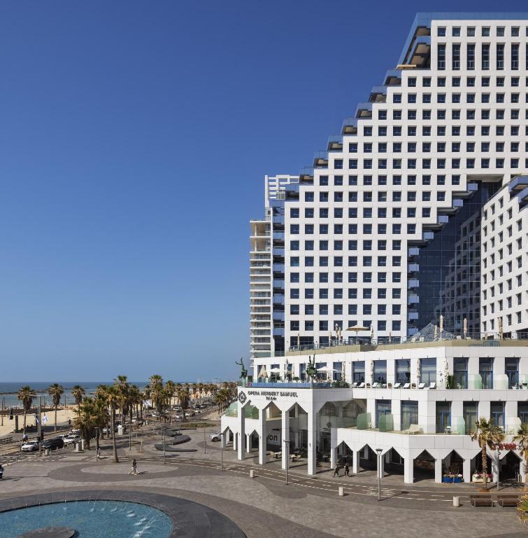 a large building on the beach next to a building at Herbert Samuel Opera Tel Aviv in Tel Aviv