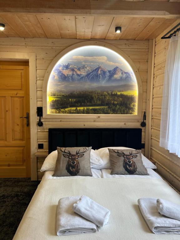 a bedroom with a large bed with a large window at Cichowiańska Chałupa przy stoku z widokiem na GÓRY I SKY WALK in Małe Ciche