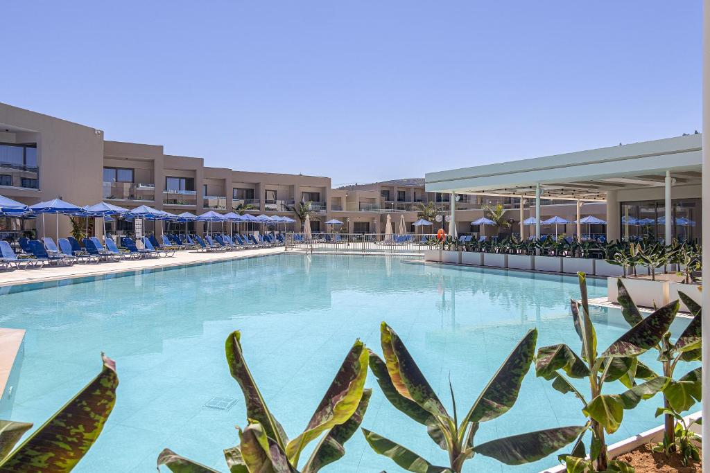 a large swimming pool with chairs and umbrellas at Rethymno Village in Platanes
