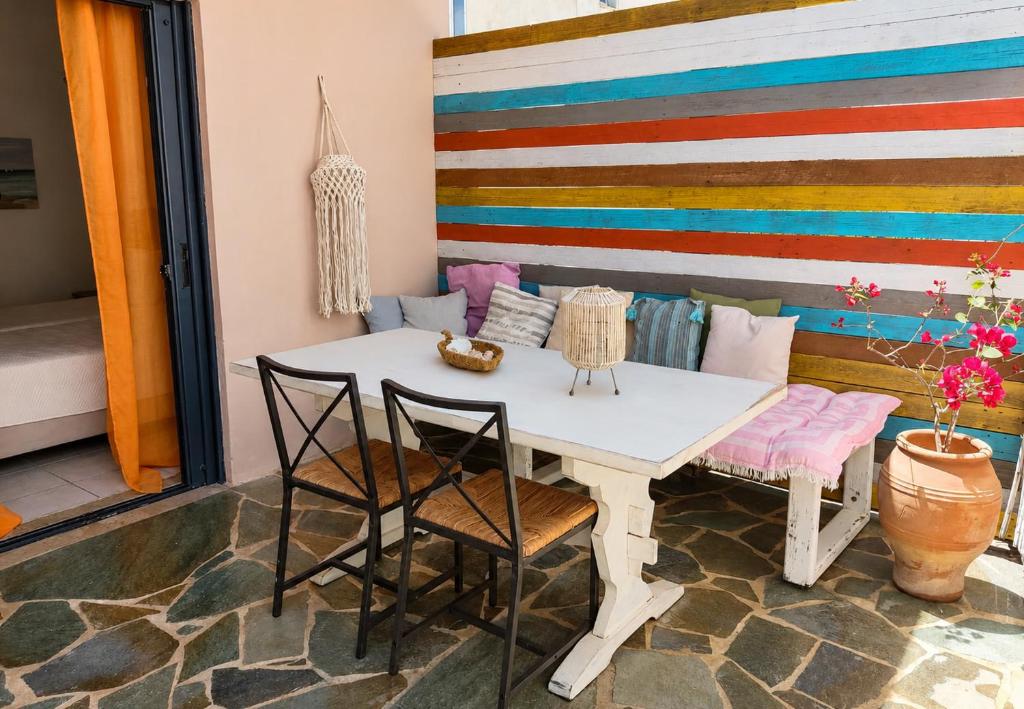 a table and chairs in a room with a colorful wall at Votsalon Beach House - 30 meters from Alykes Beach in Katastárion