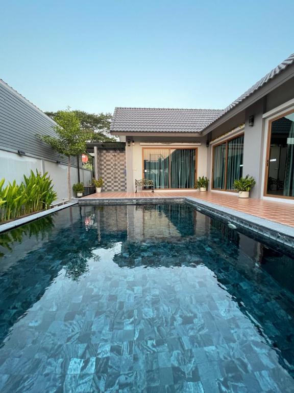 a swimming pool in front of a house at P2 Location pool villa in Ban Pak Chong