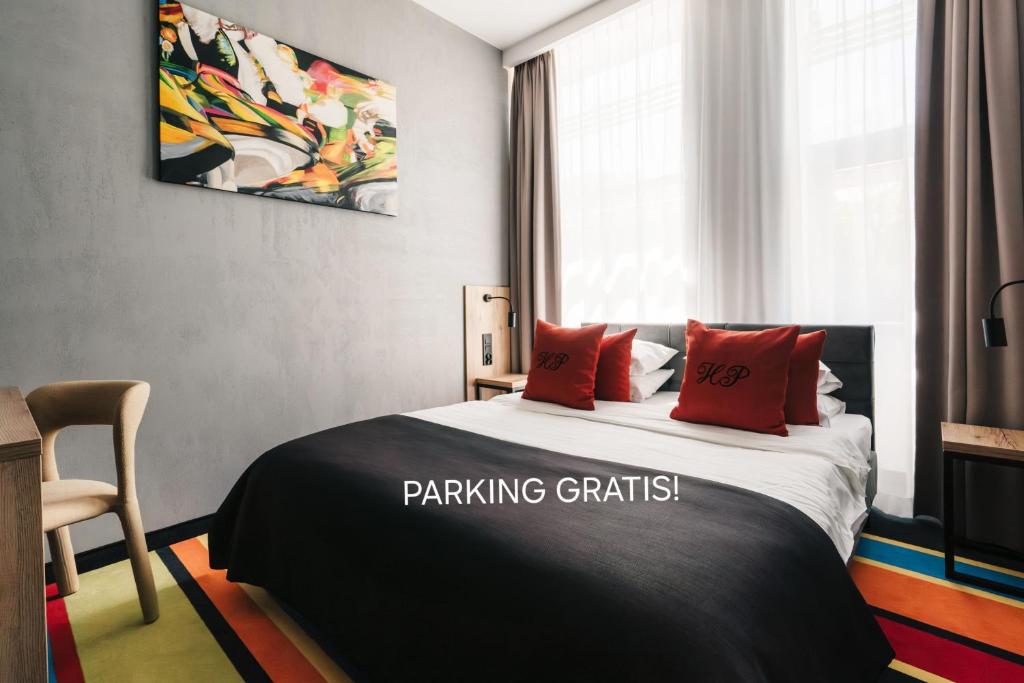 a bedroom with a large bed with red pillows at Hotel Polonez in Krakow