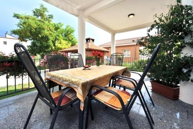 a wooden table and chairs on a patio at Clementa Apartment in Zadar
