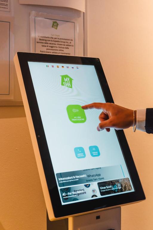 a person pointing at a tablet computer screen at mySHH Smart in Vigo di Fassa