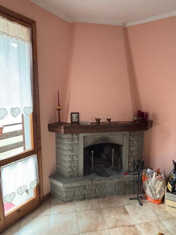 a living room with a brick fireplace with a candle at Claudia F in Pievepelago