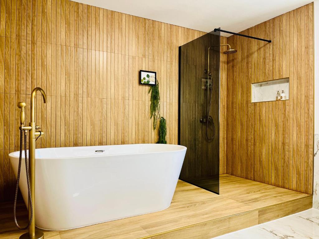 ein Badezimmer mit weißer Badewanne und Dusche in der Unterkunft Filuma Suite - Riverside Terrace on Gacka River in Otočac