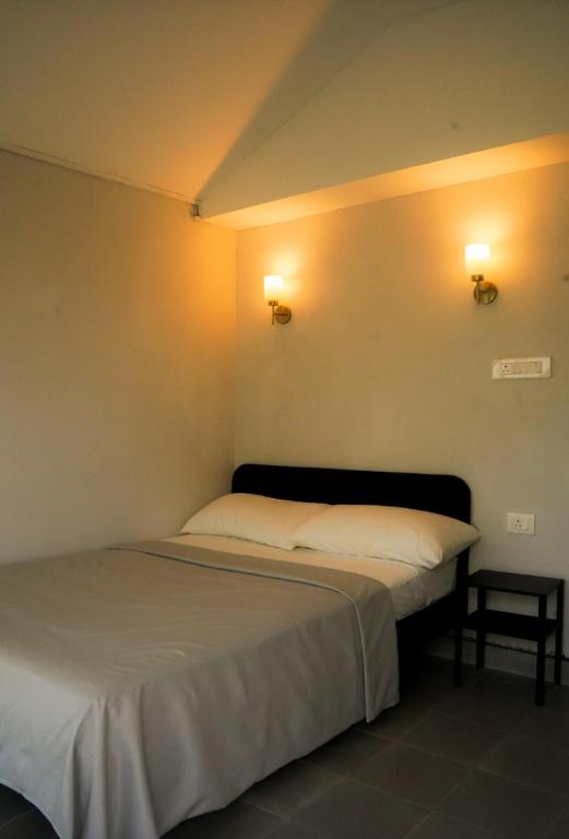 a bed in a room with two lights on the wall at Isa guesthouse in Shillong