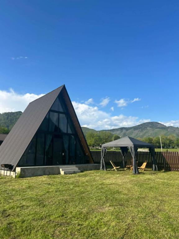 a large building with a pyramid shaped roof in a field at Sunshine Borjomi in Borjomi