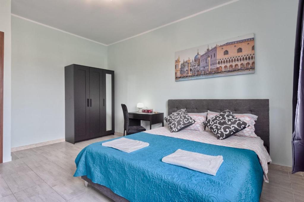 a bedroom with a blue bed and a desk at Ca Teresa 14 in Marghera