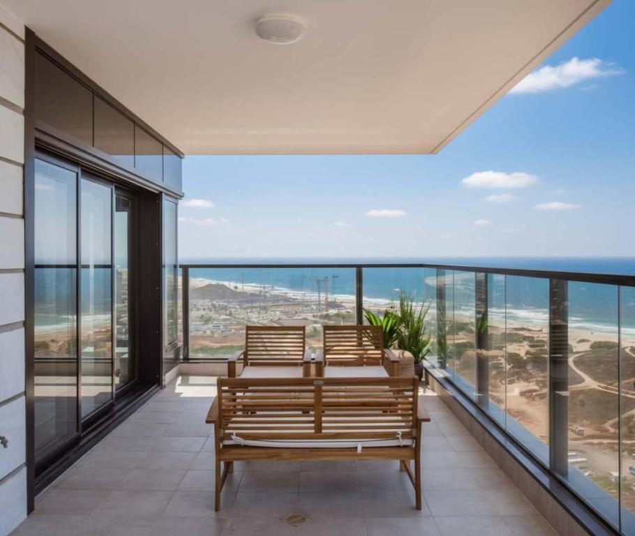 a balcony with benches and a view of the ocean at Magical 4BR APT With Panoramic Sea View l Mamad in Bat Yam