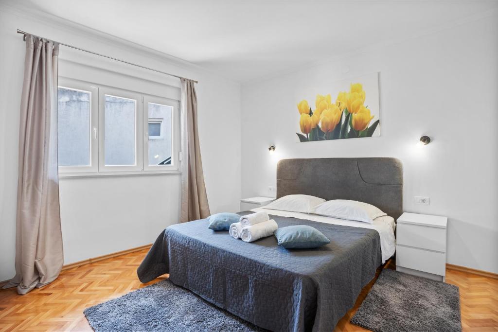 a bedroom with a large bed and a window at Apartment & Rooms - Marina in Ploče