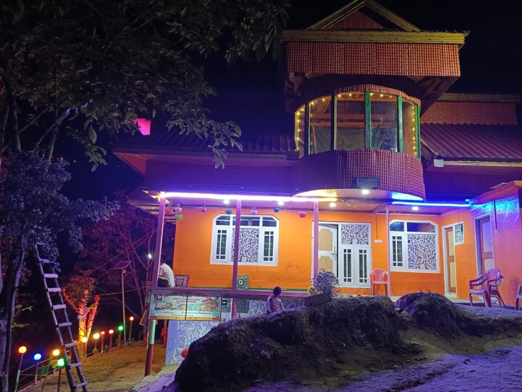a house lit up at night with purple lights at Paris Home Stay in Keran