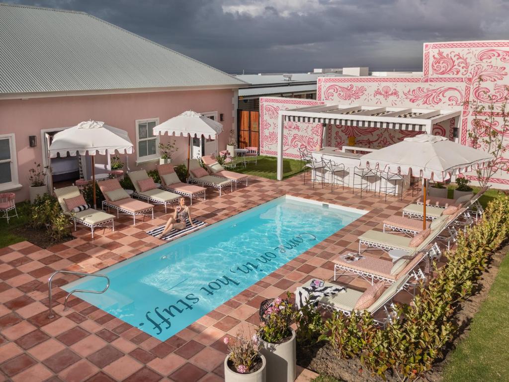 an overhead view of a pool with chairs and umbrellas at Tintswalo Summer House in Glencairn