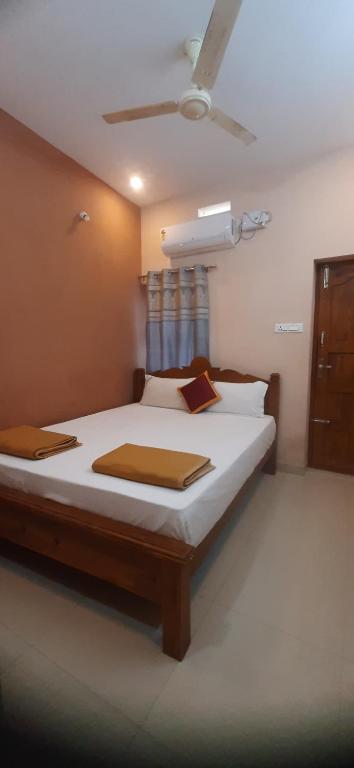 a bedroom with a large bed with white sheets at SRM Residency in Alāndurai