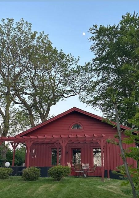 a red barn with a table and chairs in a yard at Gunnegårds gästhus in Fleninge