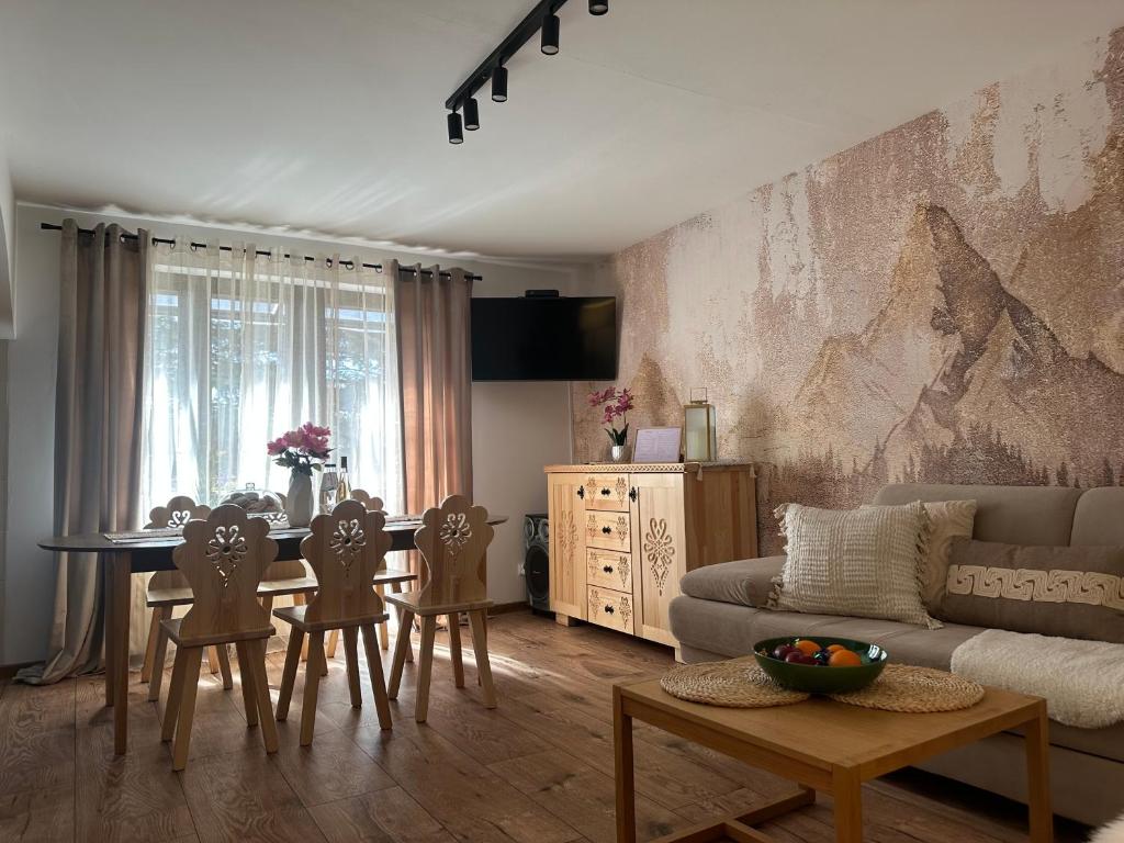a living room with a table and chairs and a couch at Domek Golasówka in Muszyna